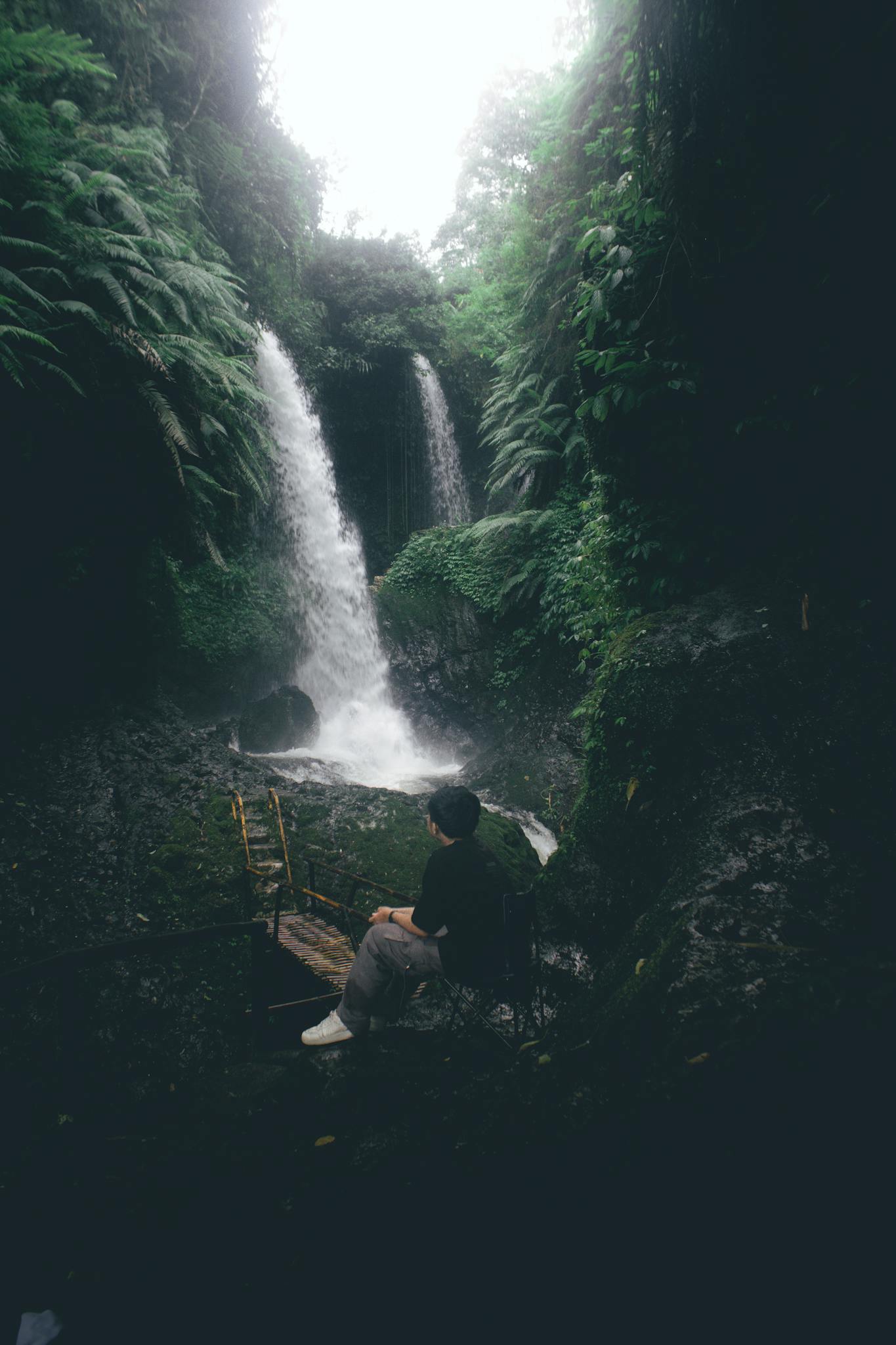Explore tranquility at a stunning twin waterfall amidst lush greenery in Bandung, Indonesia.