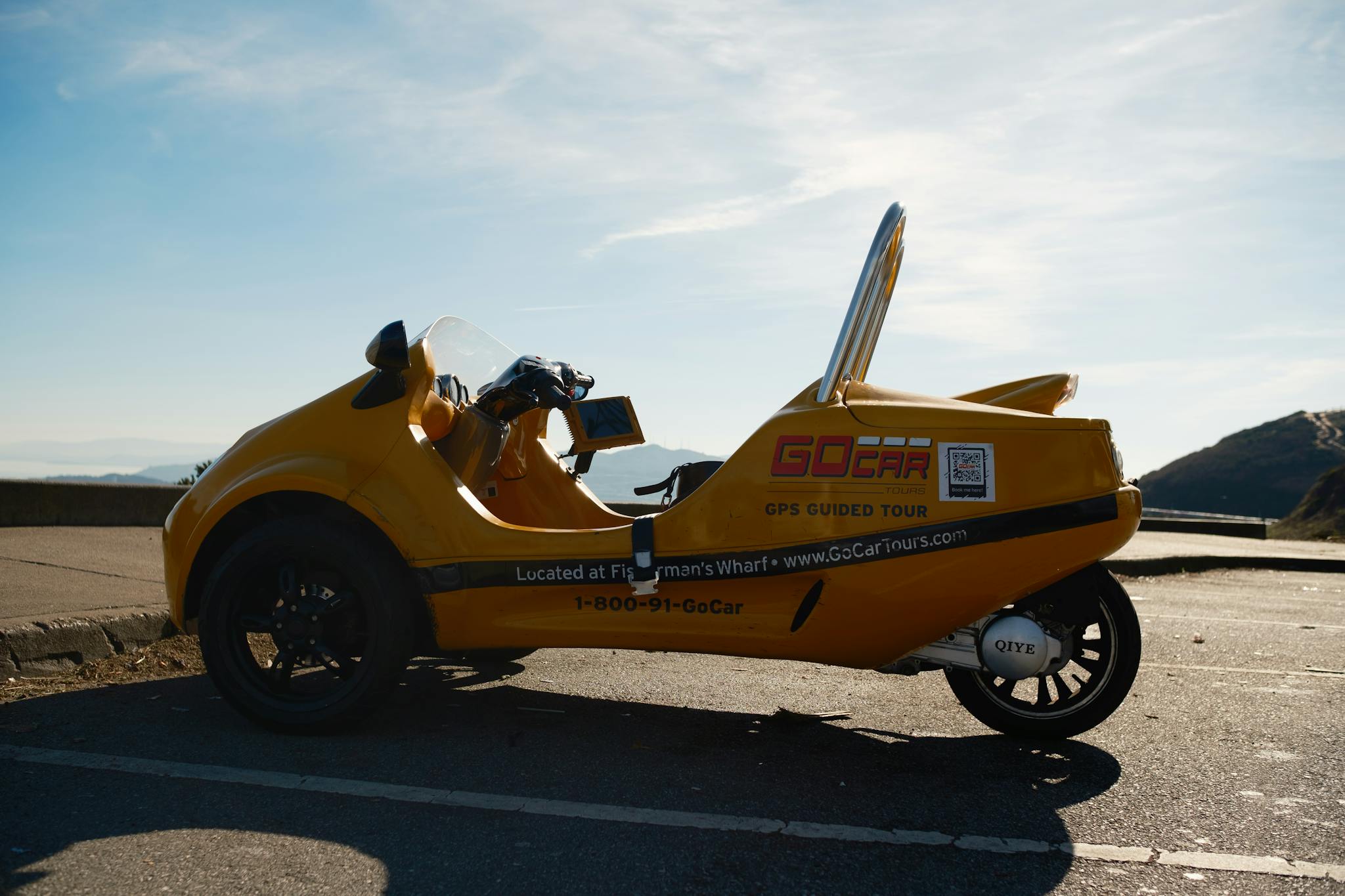 Yellow GoCar parked on a Los Angeles road with scenic views. Perfect for adventure and sightseeing.